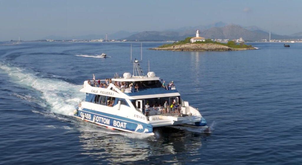 Excursión barco vision submarina pasando delante el impresionante faro de Aucnada