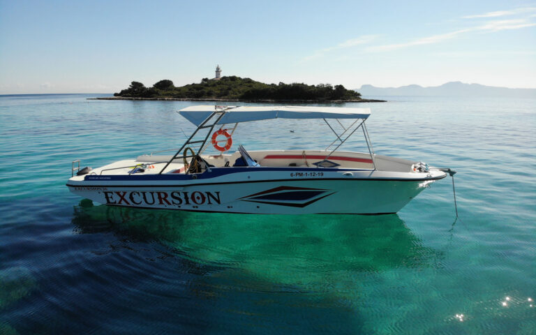 Private boat in crystal-clear waters off Alcanada Island near Alcudia, Mallorca