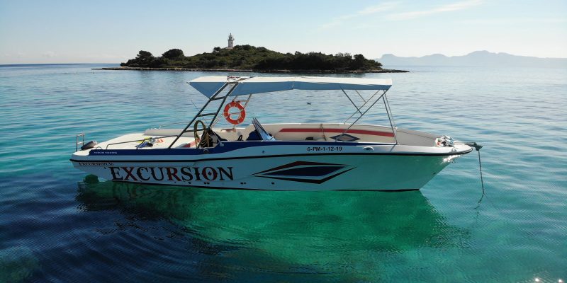 Private boat in crystal-clear waters off Alcanada Island near Alcudia, Mallorca